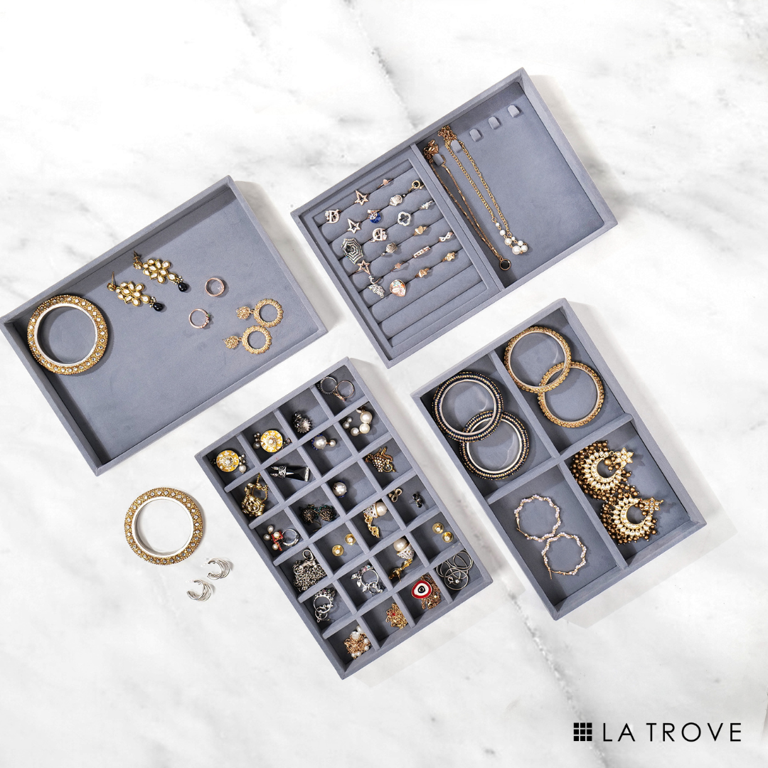 Grey stackable jewellery organizer set of 4 trays with varied compartments for accessories.